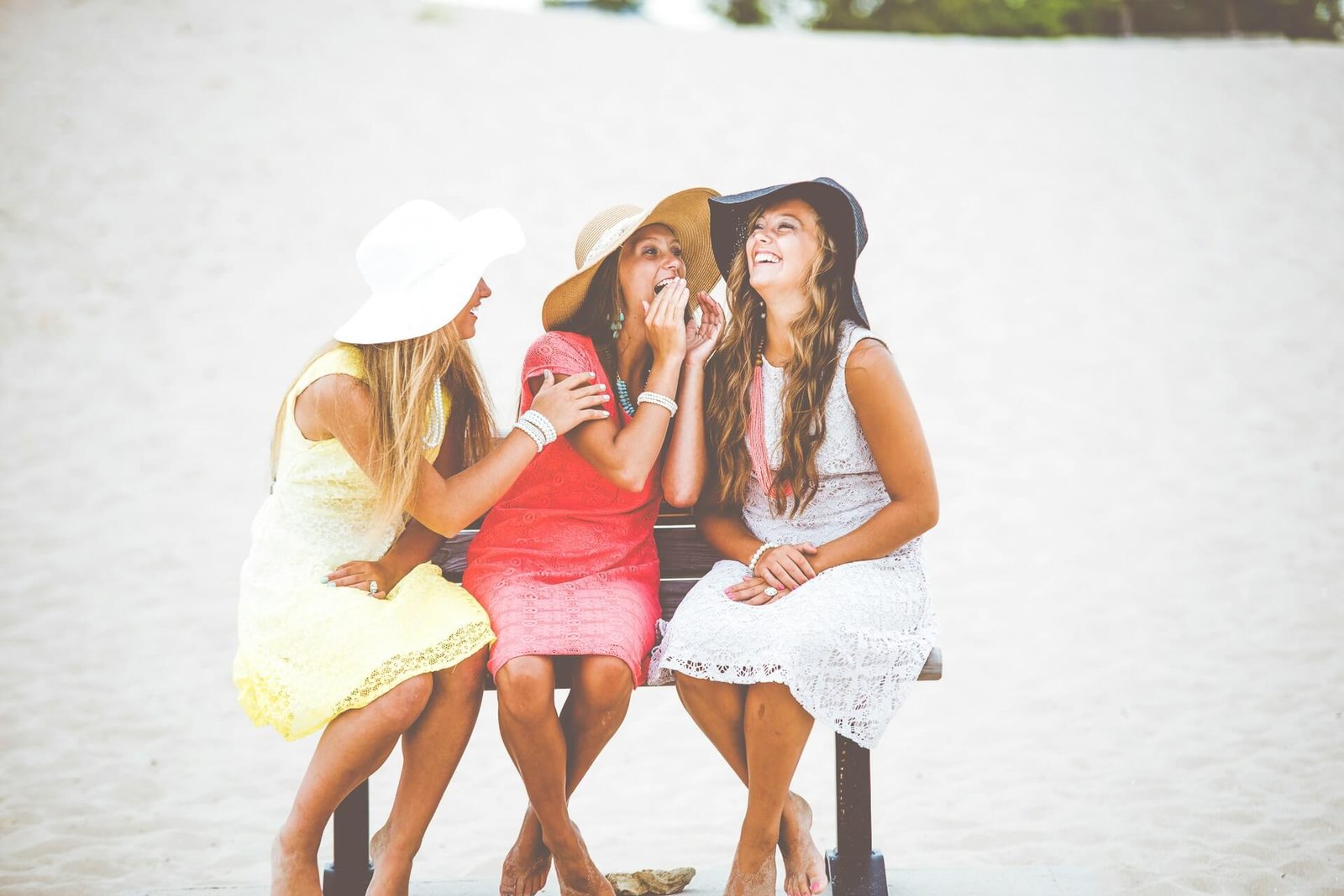 3 women on a beach laughing together