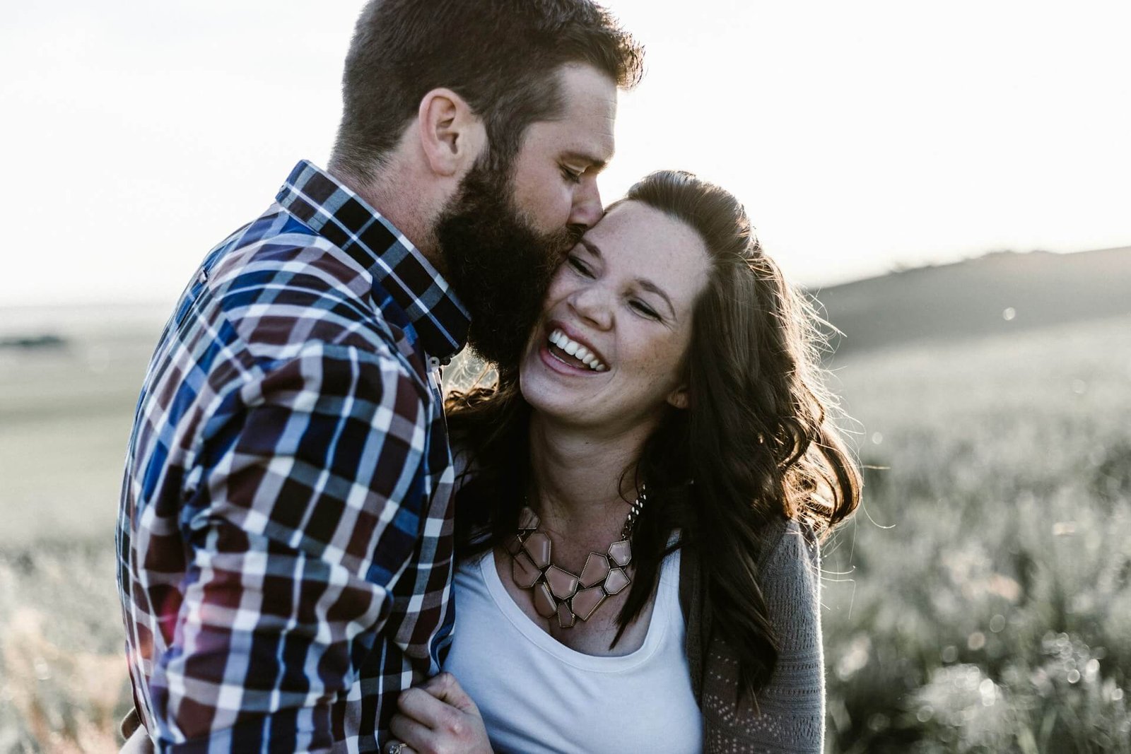 a happy couple kissing and laughing