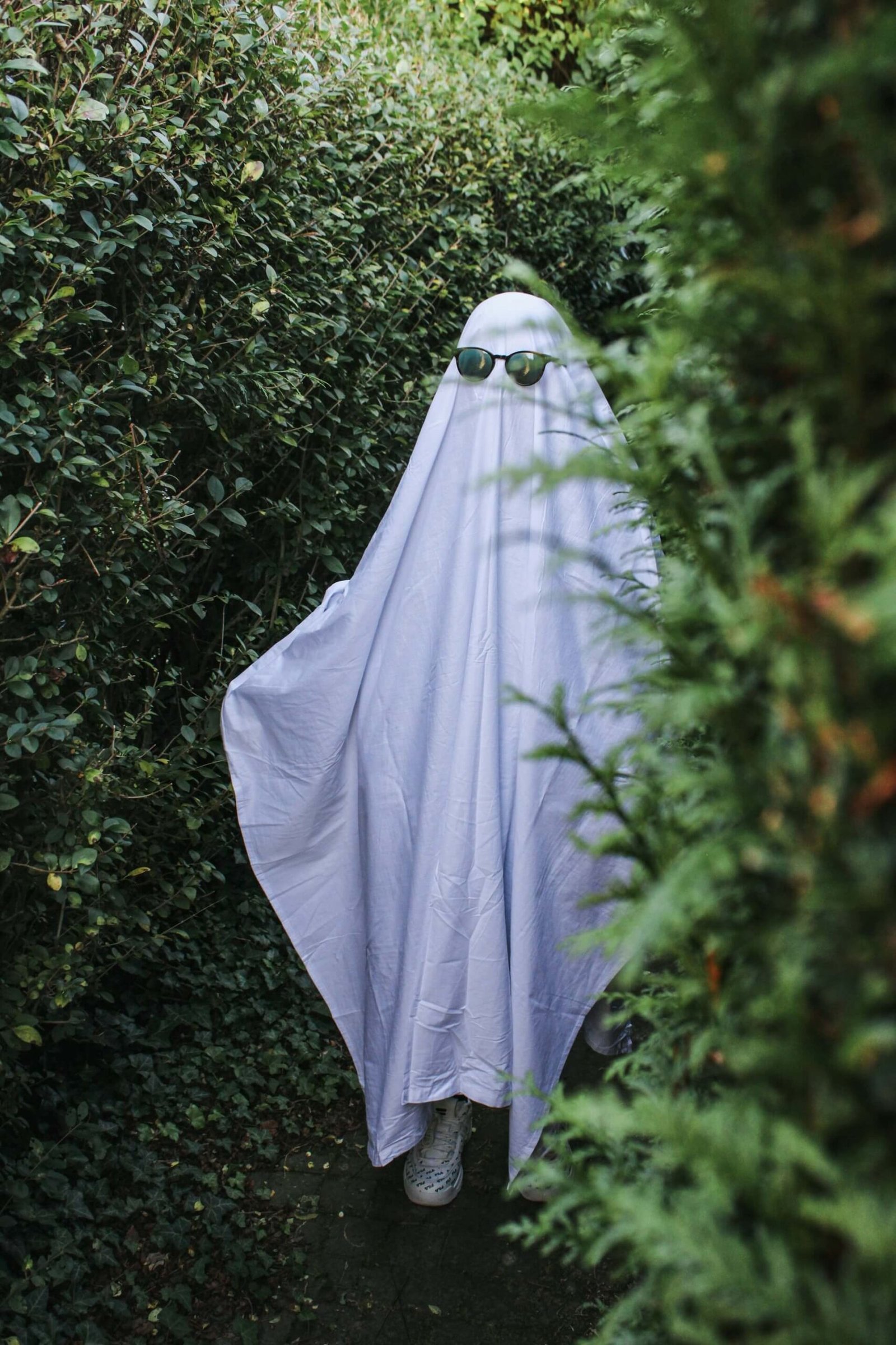 a person wearing a white sheet, dressed as a ghost